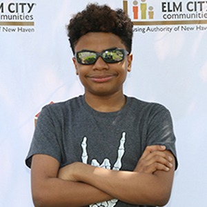 Teenage boy with arms folded in front of an ECC step and repeat